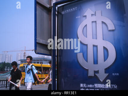 Chinesische Fußgänger vorbei an einer Anschlagtafel der Dollar Investitionen in Peking, China. 2005 Stockfoto