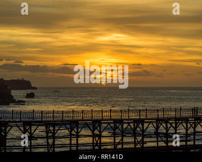 Sonnenuntergang in der Bucht von Jimbaran Bali mit Steg im Vordergrund. Stockfoto