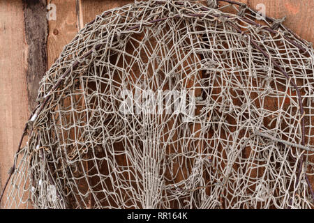 Alten Fischernetzen hängen auf Holz braun Wand Stockfoto