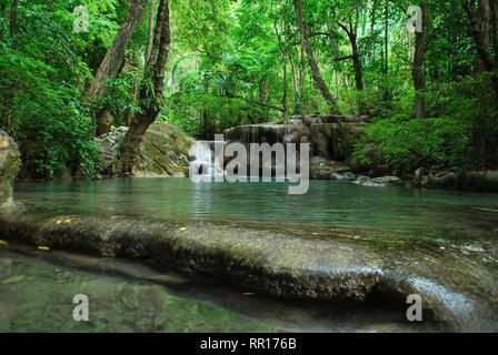 Fluss mit smaragdgrünen Wasserfall im Hintergrund in einer tiefen Regenwald Erawan Nationalpark in der Nähe von Kanchanaburi, Thailand. Stockfoto