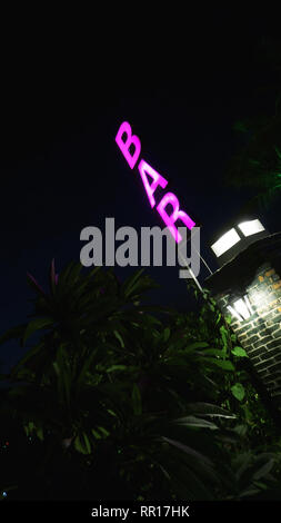 Flouresant neon pink Bar Schild - Vertikaler schwarzer Hintergrund Stockfoto