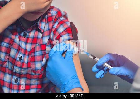 Close-up Hände Arzt oder Pflegepersonal Impfung mit der Spritze zu Patienten injiziert Oberarm für behandelt. Arzt, eine Injektion zu einem Patienten Stockfoto