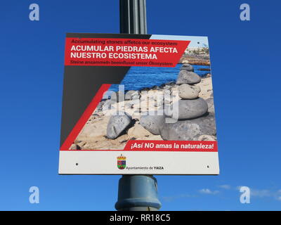 Öffentliche Bekanntmachung an der Promenade von Playa Blanca, die besagt, dass die Anhäufung von Steinen über Rock Art Formationen der Strand Ökosystem schädlich ist. Stockfoto