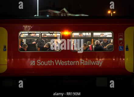 Pendler in einem überfüllten South Western Eisenbahn Zug aus London weg in Clapham Junction in der abendlichen Hauptverkehrszeit Rubrik Stockfoto