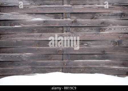 Alte geschneit Holzzaun des grauen ungeplante Planken, können als Hintergrund oder Textur verwendet werden. Stockfoto