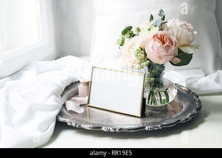 Frühling, Sommer still life Szene. Leere goldene Bilderrahmen alten Silber Fach an der Fensterbank. Vintage feminin Foto. Florale Komposition. Blumenstrauß aus Stockfoto
