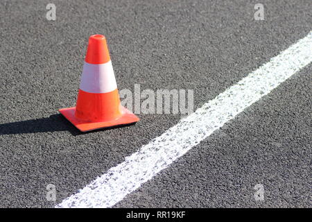 Leitkegel mit weißem Streifen auf der Asphaltstraße Stockfoto