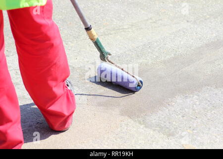 Anwendung von Epoxy mit Walze auf die saubere Beton auf der Brücke Stockfoto