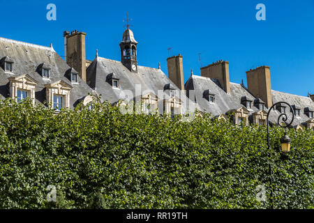 Die grauen Schieferdächern Zimmer im Dachgeschoss und Schornsteine der Gebäude in der Umgebung der Place des Vosges im modischen Viertel Le Marais Paris, Frankreich Stockfoto