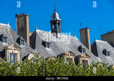 Die grauen Schieferdächern Zimmer im Dachgeschoss und Schornsteine der Gebäude in der Umgebung der Place des Vosges im modischen Viertel Le Marais Paris, Frankreich Stockfoto