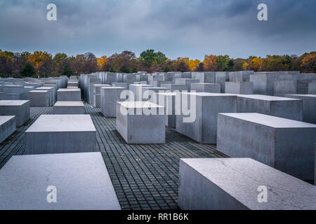 Jüdische Gedenkstätte aus Beton Bausteine mit Herbstfarben auf die Bäume im Hintergrund in Berlin Deutschland. Stockfoto