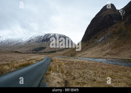 Eine Straße entlang des Flusses Etive unter den Bergen des Glen Etive Tal im frühen Frühjahr, Western Highlands, Schottland, Großbritannien. Stockfoto