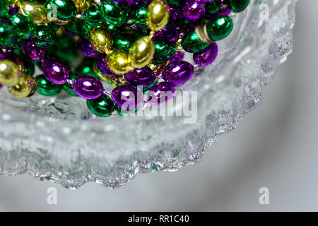 Makro Kunst abstrakt der traditionellen drei Farbe Mardi Gras Perlen in einem satiniertem Kristallglas Schale Stockfoto