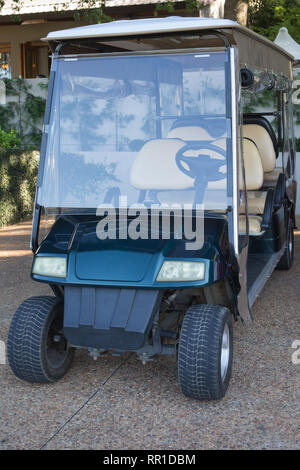 Golf Warenkorb oder Buggy, grün 6 Sitzer und lange, geparkt im Freien an einem Parkplatz vor einem Gebäude und als Shuttle oder Transport Stockfoto