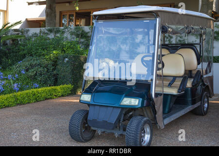 Golf Warenkorb oder Buggy, grün 6 Sitzer und lange, geparkt im Freien an einem Parkplatz vor einem Gebäude und als Shuttle oder Transport Stockfoto