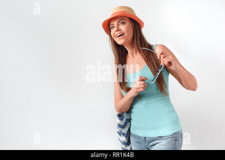Sommer Stimmung. Frau mit Hut stehend Studio isoliert auf Weiss mit badetasche Sonnenbrille Holding freuen uns aufgeregt Stockfoto