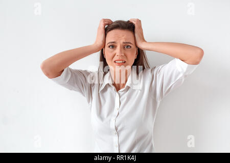 Freestyle. Frau stehen auf weißen Holding Kopf isoliert besorgt Stockfoto