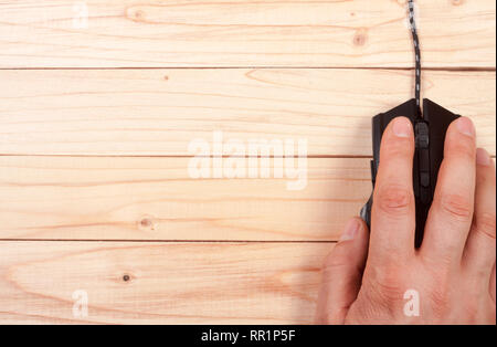 Schwarz Computer Maus mit einer Hand auf einem hellen Hintergrund mit Kopie Platz für Ihren Text. Ansicht von oben Stockfoto