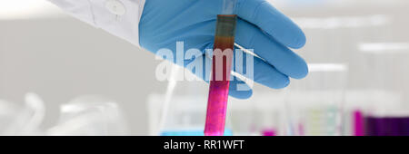Eine männliche Chemiker hält Reagenzglas von Glas in Stockfoto