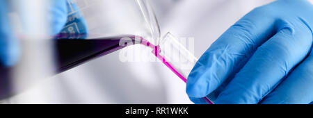 Eine männliche Chemiker hält Reagenzglas von Glas in Stockfoto