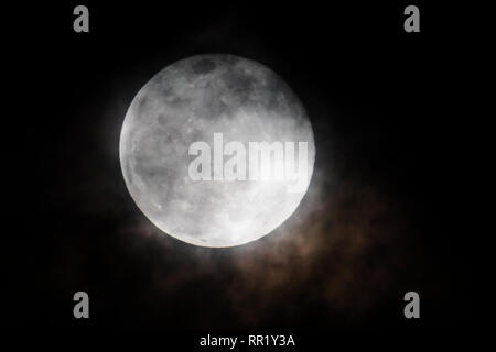 Voll super Schnee Mond steigt durch Wolken über Rocky Mountains, Salida, Colorado, USA Stockfoto