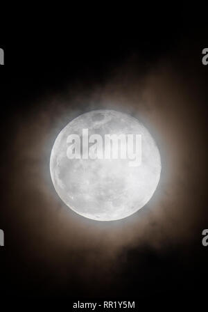 Voll super Schnee Mond steigt durch Wolken über Rocky Mountains, Salida, Colorado, USA Stockfoto