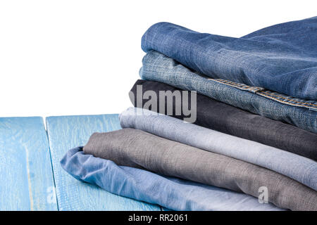 Stapel von Jeans auf Blau Holz- Hintergrund Stockfoto