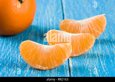 Tangerine Schichten auf einem blauen Hintergrund aus Holz Stockfoto