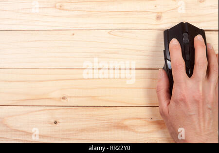 Schwarz Computer Maus mit einer Hand auf einem hellen Hintergrund mit Kopie Platz für Ihren Text. Ansicht von oben Stockfoto