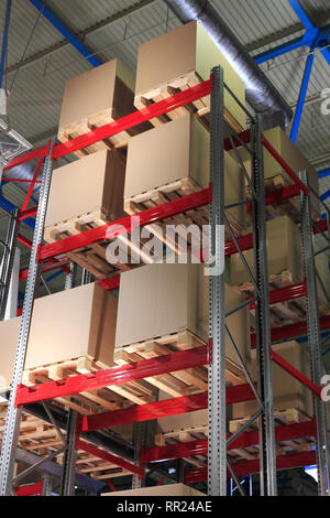 Kartons auf Paletten und Regalen im Lagerhaus. Stockfoto