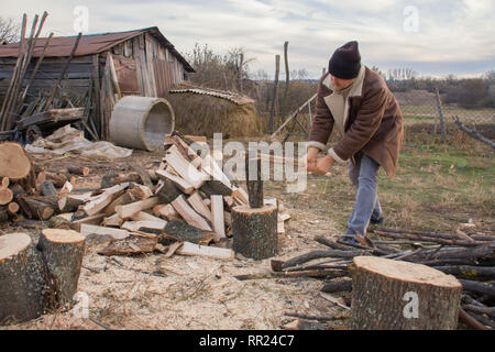 Man Holzhacken im Dorf Stockfoto