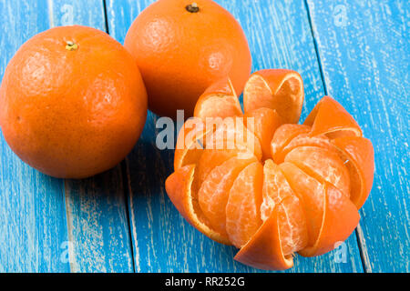 Drei tangerine auf einem blauen Hintergrund aus Holz Stockfoto