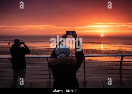 Blackpool, Großbritannien. 23. Februar 2019, Blackpool, Blackpool, Lancashire Holiday Maker capture Die untergehende Sonne aus Blackpool Promenade Credit: Fotografieren Nord/Alamy leben Nachrichten Stockfoto