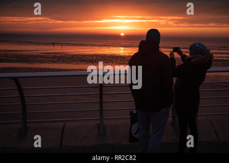 Blackpool, Großbritannien. 23. Februar 2019, Blackpool, Blackpool, Lancashire Holiday Maker capture Die untergehende Sonne aus Blackpool Promenade Credit: Fotografieren Nord/Alamy leben Nachrichten Stockfoto