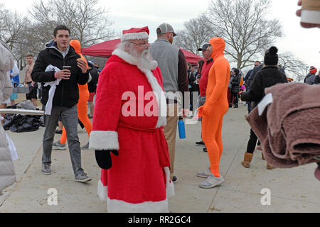 Cleveland, Ohio, USA. 24 Feb, 2019. Santa macht sich auf den Weg durch die Menge der fellow Polar Plunge Teilnehmer Edgewater Park in Cleveland, Ohio, USA. Über 400 Teilnehmer trotzten die Elemente durch ein Bad im Ice-beladenen Ufer Wasser des Lake Erie. Der Spaß jährliche Veranstaltung ermutigt die Menschen in Kostümen zu kleiden, wie Sie Geld für die Special Olympics anheben. Credit: Mark Kanning/Alamy Leben Nachrichten. Stockfoto