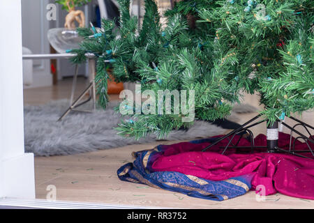 Unten auf einen künstlichen Weihnachtsbaum, auf einem Stand in ein Wohnzimmer eingerichtet, bereit, mit Ornamenten verziert, aber leer. Stockfoto