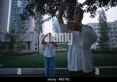 Bildunterschrift: Chengdu, Sichuan, China - August 2003. Praktiker von Tai-Chi und seine derivities engagieren sich in einem frühen Morgen Sitzung der Kampfkunst durch die Stockfoto