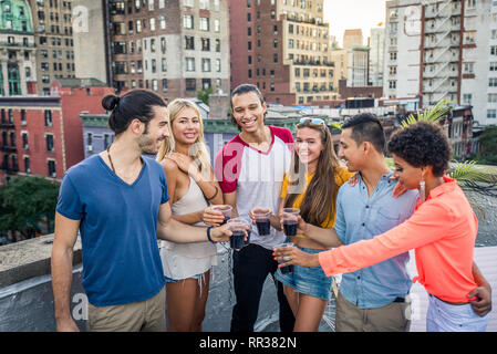 Junge Menschen glücklich mit einem Barbecue Dinner auf einem Dach in New York - Gruppe von Freunden in Partei und Spaß haben Stockfoto