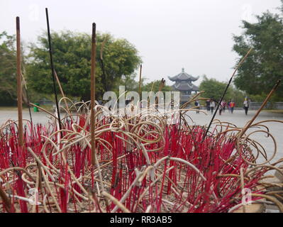 Brennende rote Räucherstäbchen in einen großen Topf an einem Tempel in der Nähe von Hanoi Stockfoto