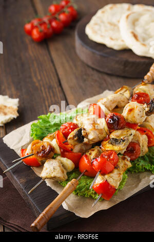 Die Türkei oder Hühnchen Shish Kebab Spieße mit Pilzen und Pitas auf Holzbrett. Stockfoto
