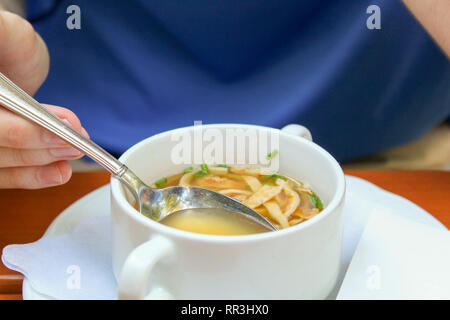 Closeup junger Mann heiße Suppe essen im Biergarten oder im Restaurant Stockfoto