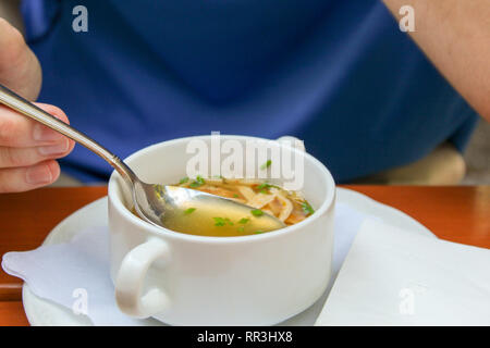 Closeup junger Mann heiße Suppe essen im Biergarten oder im Restaurant Stockfoto