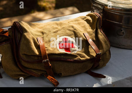 Sunlit Vintage Military chirurgische Tasche aus Plane, steht auf einem Tisch. Medizinische rote Kreuz patch mit einer Tasche Stockfoto