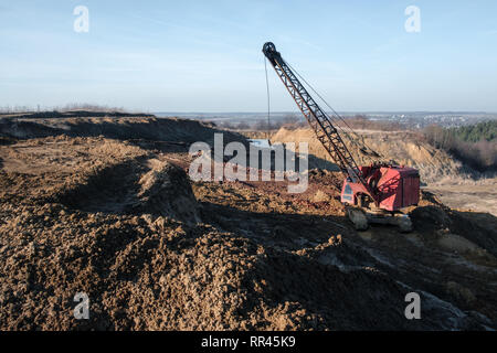 Bagger in den roten Lehm Steinbruch. Industriellen Hintergrund Stockfoto