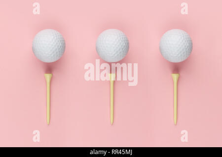 Drei Golf ball und Holz- T-Stück auf rosa Hintergrund closeup Stockfoto