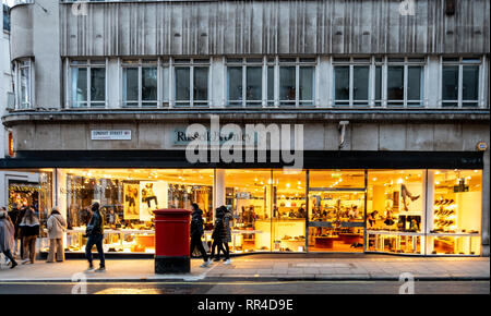 London, Großbritannien, 29. Dezember 2018: Licht scheint einladend aus dem Schuh shop Russell und Bromley auf der Conduit Street Stockfoto