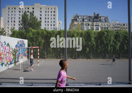 Kinder spielen auf einem umzäunten Fußballplatz, Jardins d'Eole, Rue du département, 75018, Paris, Frankreich Stockfoto