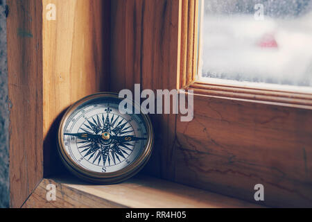 Kompass auf Holz- Fenster für Reise- und Navigationskonzept Stockfoto