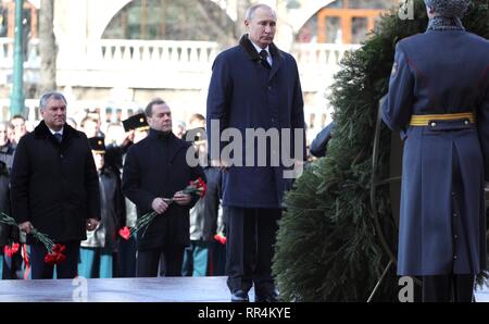 Moskau, Russland. 23 Feb, 2019. Der russische Präsident Wladimir Putin in einen Kranz am Grabmal des Unbekannten Soldaten an der Kremlmauer zur Erinnerung an die gefallenen Soldaten auf Verteidiger des Vaterlandes Tag Februar 23, 2019 in Moskau, Russland, zu ehren. Ministerpräsident Dimitri Medwedew, Mitte, und Sprecher der Duma Vyacheslav Volodin, links, hinter stehen. Credit: Planetpix/Alamy leben Nachrichten Stockfoto