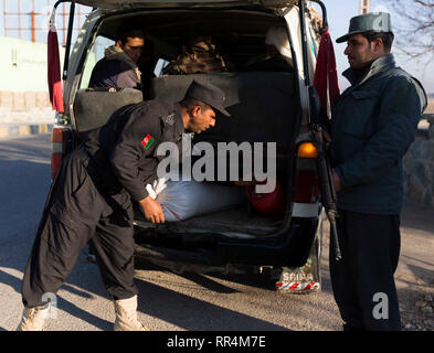 Herat, Afghanistan. 24 Feb, 2019. Ein afghanischer Polizist (L, Vorderseite) sucht ein Fahrzeug ein Security Checkpoint entlang Herat-Farah Hauptstraße in Herat, Afghanistan, 24.02.2019. Die afghanischen Sicherheitskräfte neun Taliban Kämpfer getötet haben und beschlagnahmt fast 900 kg Suchtstoffen während separate Arbeitsgänge, das Afghanische Ministerium für Inneres sagte Samstag. In der Provinz Herat, der afghanischen nationalen Polizei (ANP) ergriff mehr als 570 kg von Betäubungsmitteln und Opium und ein Fahrzeug nach dem ANP legte einen Hinterhalt und engagierte sich mit Drogenhändlern an einer Hauptstraße. Credit: Elaha Sahel/Xinhua/Alamy leben Nachrichten Stockfoto